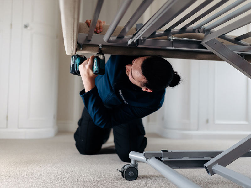 Opera installer using a drill under an Opera profiling bed.