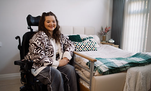 Social media influencer Amy Pohl sat in a mobility chair next to an Opera profiling bed