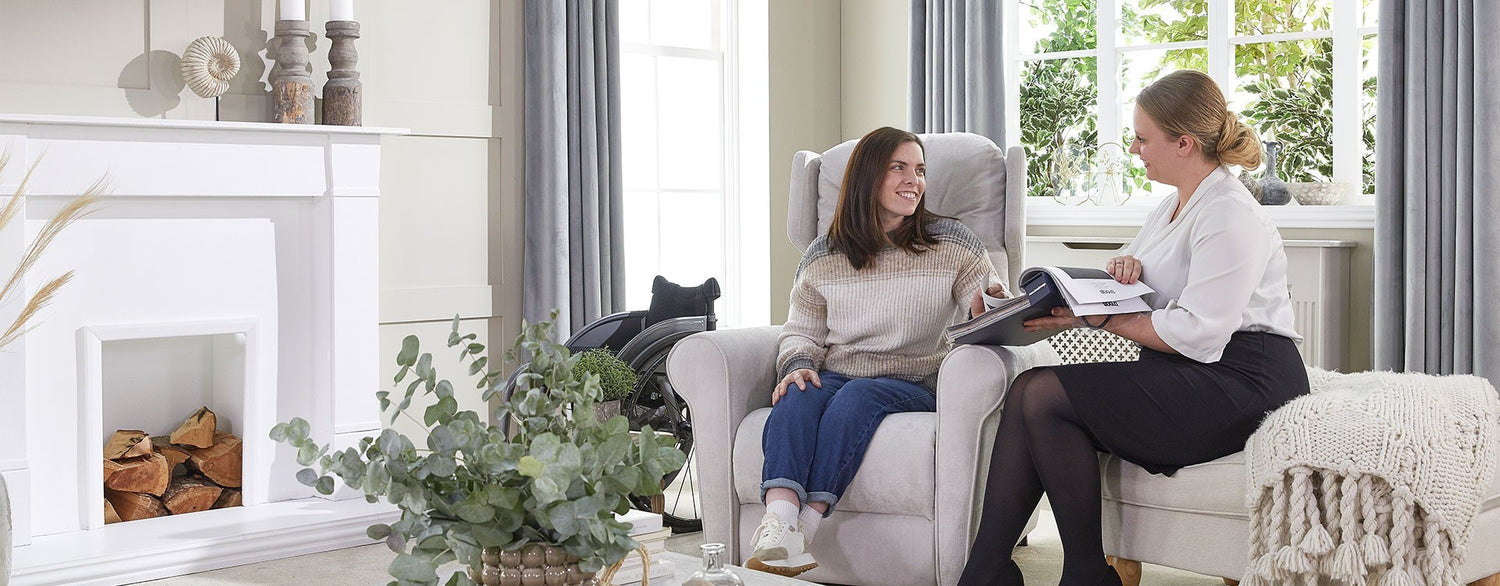Opera Beds employee showing fabric samples to a woman in a riser recliner chair