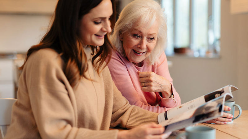 Mother and Daughter looking at an Opera Beds brochure at the kitchen table.