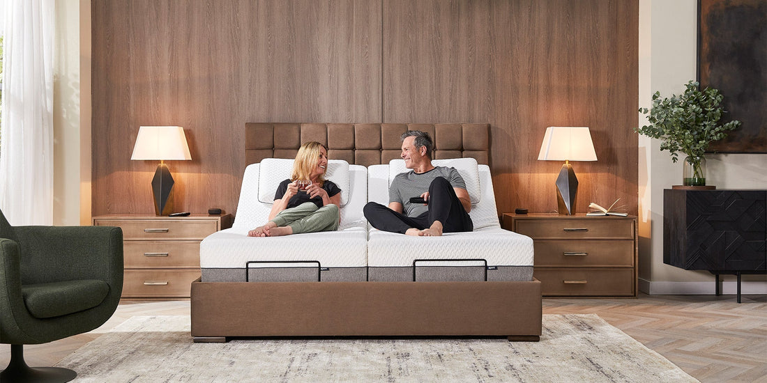 A couple sat in an Opera adjustable bed smiling at each other