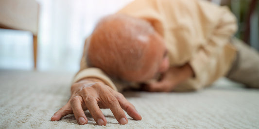 An older gentleman on the floor with his arm out