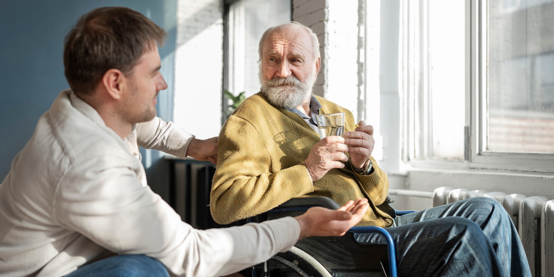 A older gentleman sat in a wheelchair next to his son