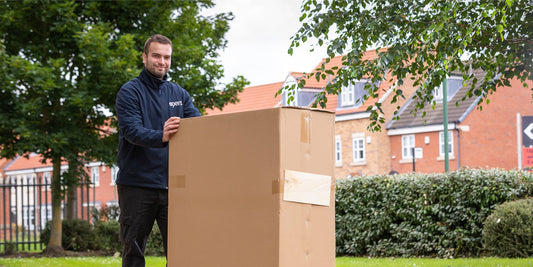 A man wearing an Opera jacket pushing a cardboard box on a trolley