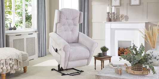 A light grey riser recliner chair in a raised position on a cream carpet 