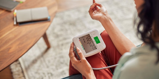 A younger lady taking her blood pressure at home 