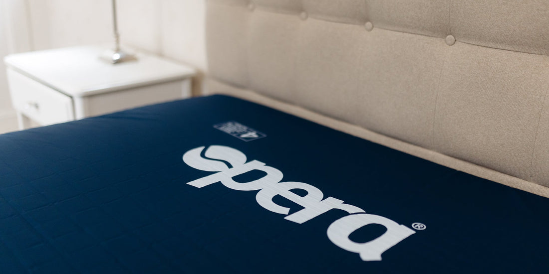 A close up of a bed with a blue mattress with the Opera logo in white