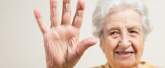 A elderly lady holding 5 fingers up