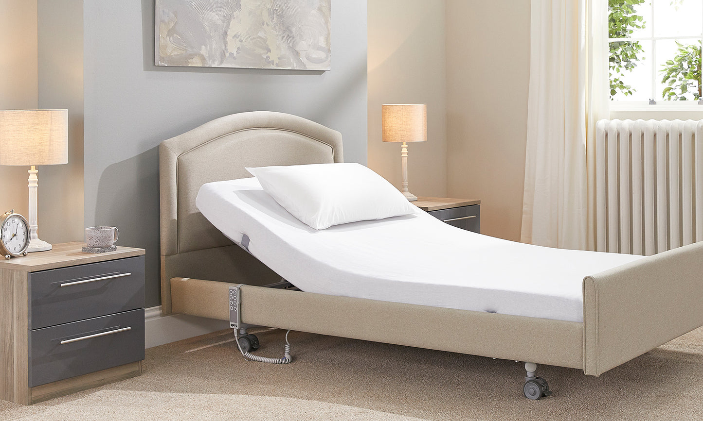 An adjustable bed with the headrest raised. The mattress has a white cotton sheet and pillow