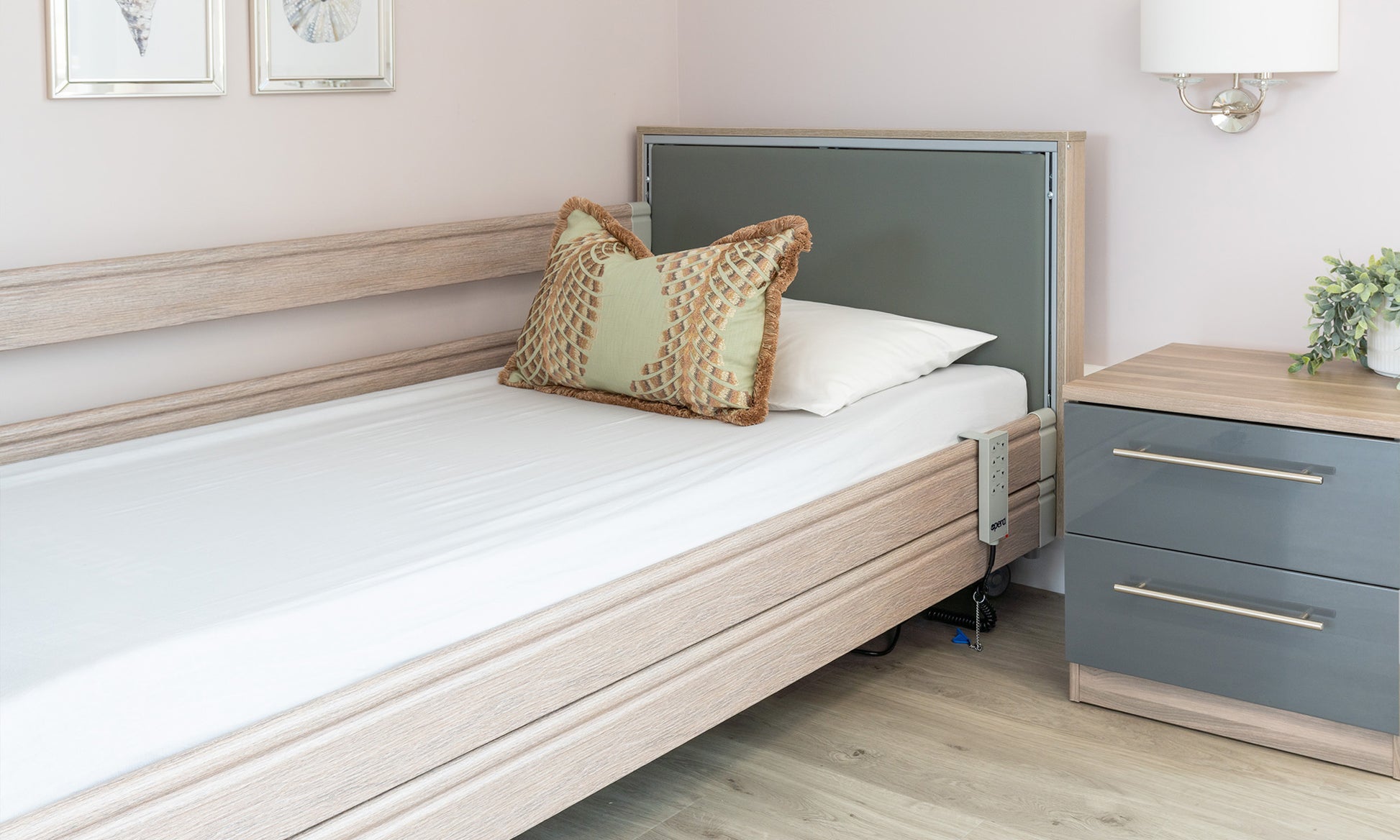 A profiling bed with mattress in a white cotton sheet.