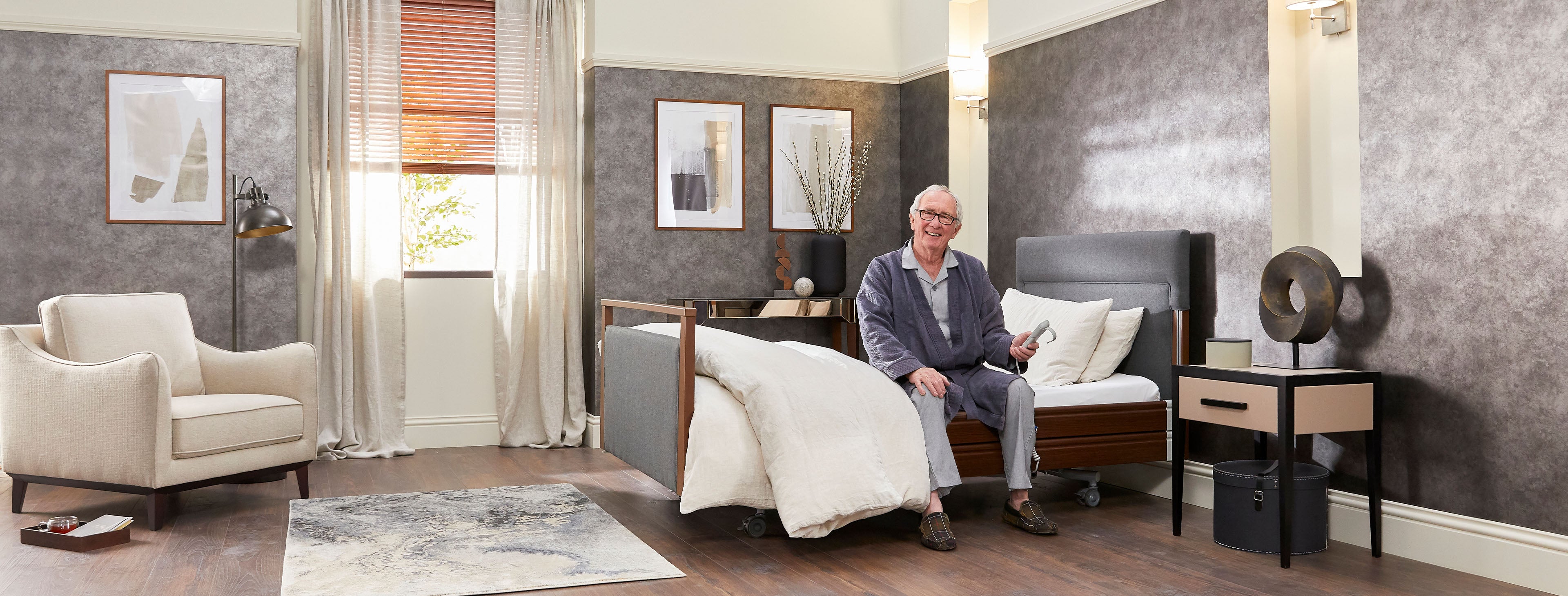 Older man with arthritis sat on a profiling bed