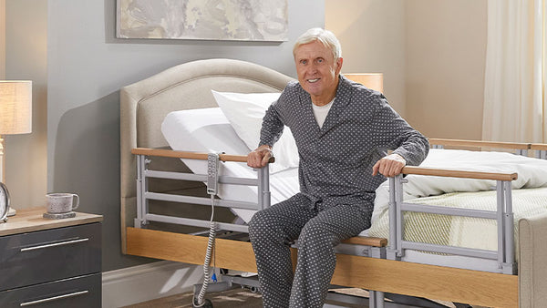 Older man getting out of an Opera profiling bed, using the side rails.