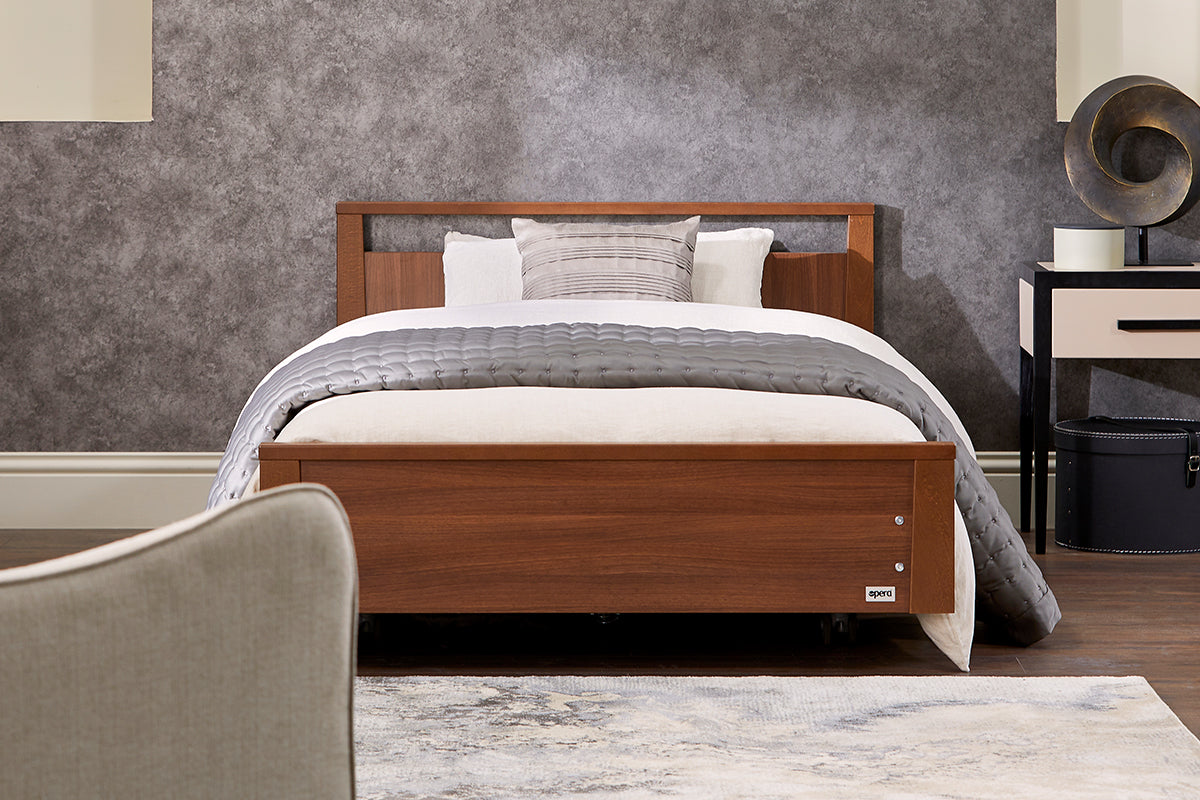 An Opera signature low footboard profiling bed in walnut wood colour