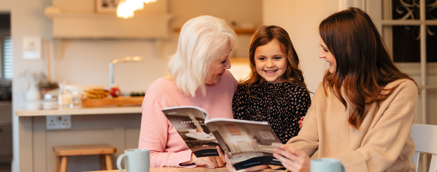 Grandma, Granddaughter and mother smiling and looking at an Opera brochure.