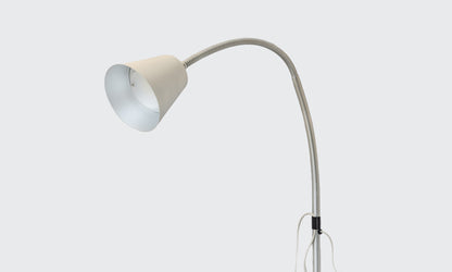 Overbed reading lamp in silver on a grey background