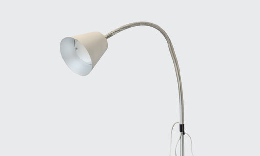 Overbed reading lamp in silver on a grey background