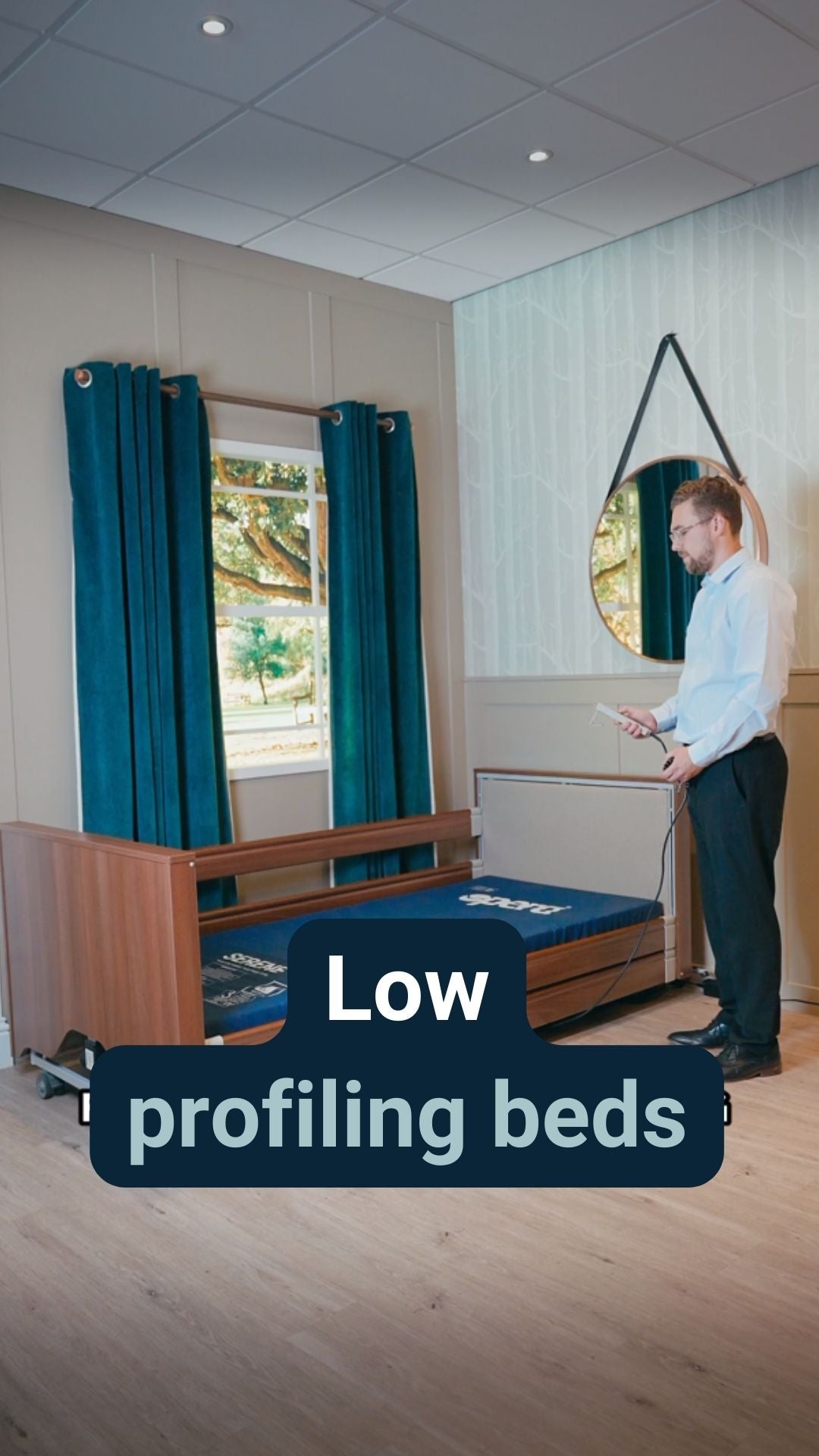 A man stood next to a low profiling bed with the caption 'Low profiling beds'