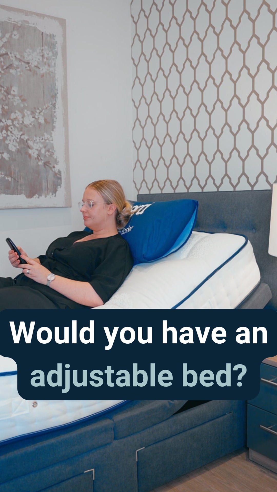 Woman in a black shirt on an Opera adjustable bed with caption reading: Would you have an adjustable bed?